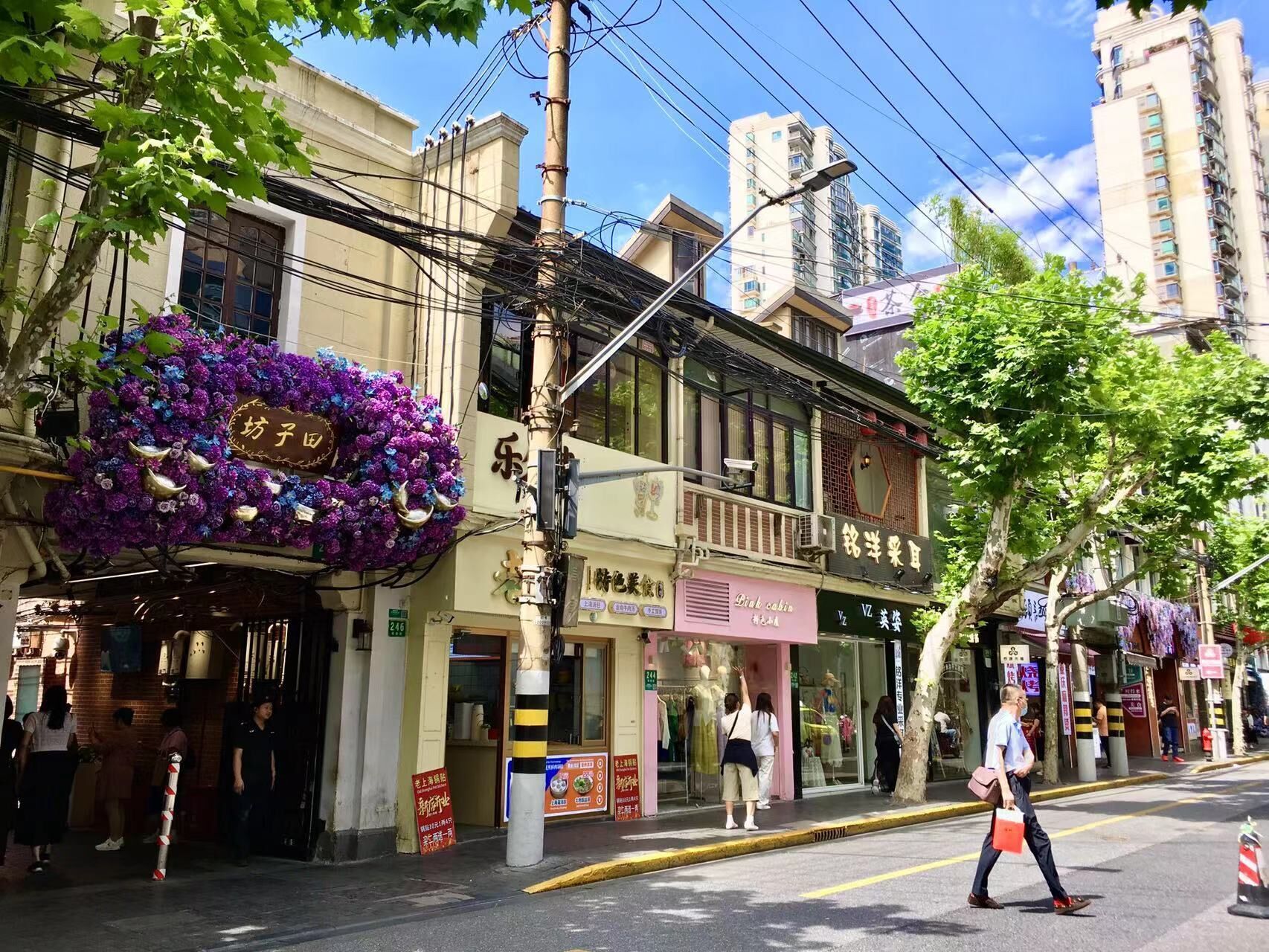 Vista de una calle con edificios, un paso de peatones y una persona caminando.