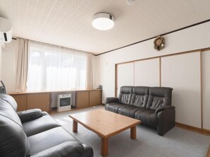 A modern living room with a sofa, a coffee table, a fireplace, and a sliding door.