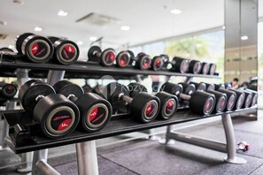 A gym with rows of dumbbells on racks. - Astera by Kozystay - Kuningan (South Jakarta)