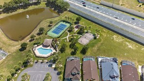 A residential area with a swimming pool, tennis courts, and a highway. - Spacious 5BR Pool Home Near Disney (Davenport)