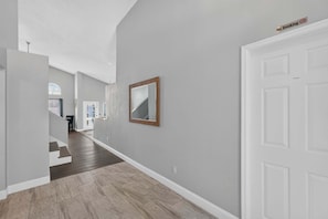 A hallway with a white door, a 'No Smoking' sign, and a mirror on the wall. - Golden Light Retreat | 5BR Davenport w/ Pool (Davenport)