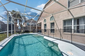 A swimming pool with a clear blue water, surrounded by a covered area with a roof structure. - Golden Light Retreat | 5BR Davenport w/ Pool (Davenport)