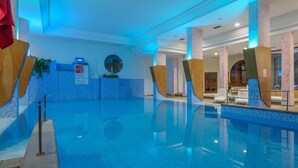 Vestíbulo de hotel con zona de piscina, mostrador de recepción y un cartel de Parc Hotels Italia.
