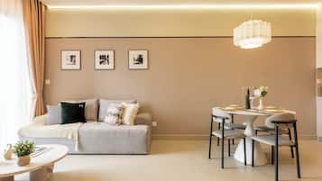 A modern living room with a sofa, a dining table with chairs, and three framed pictures on the wall.