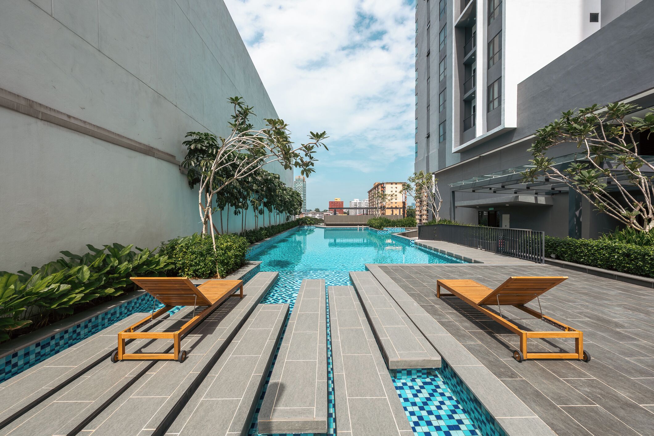 A swimming pool with lounge chairs and a view of surrounding buildings.