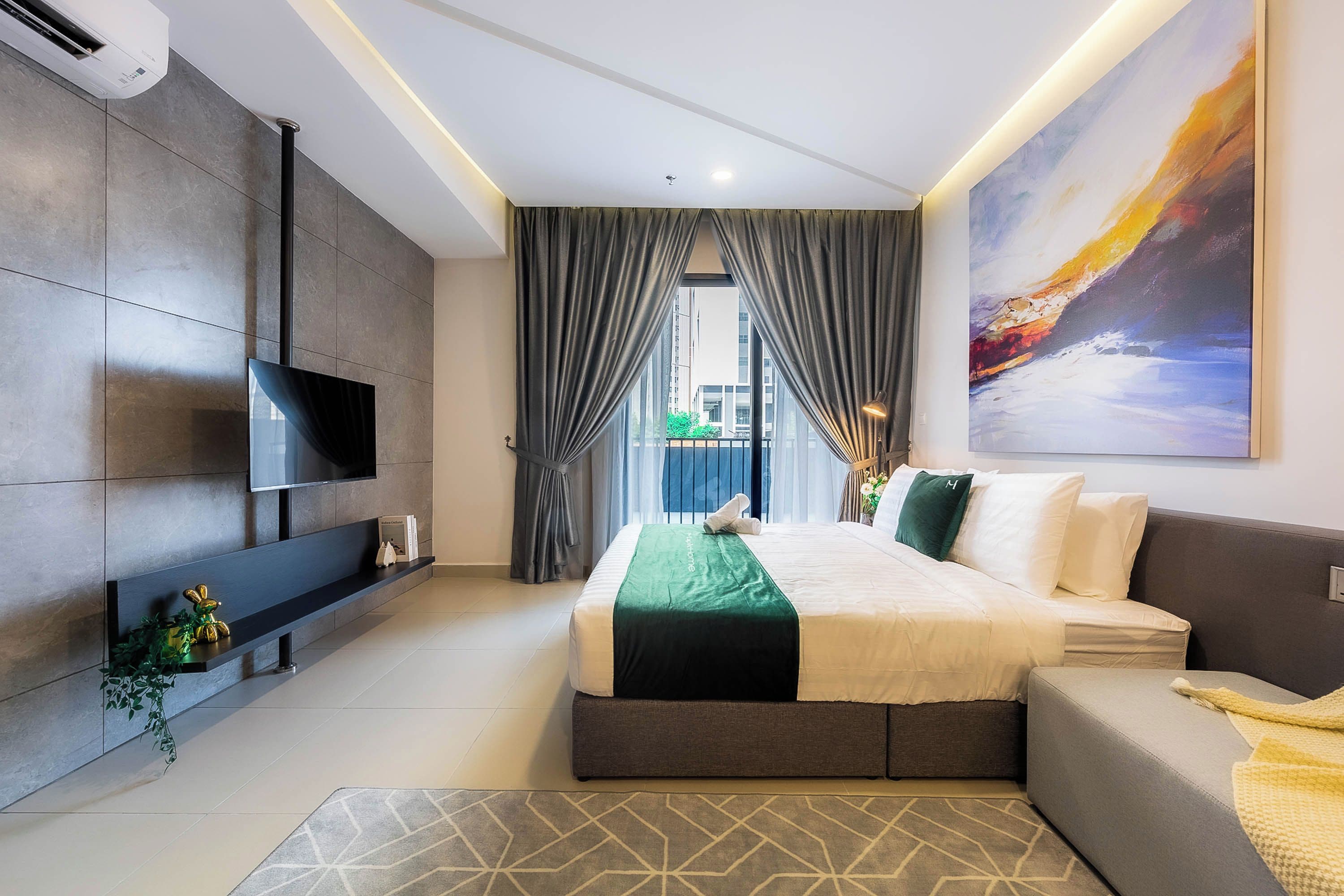Une chambre d’hôtel moderne, dotée d’un grand lit, d’un téléviseur à écran plat, d’un canapé et d’un tableau au mur.