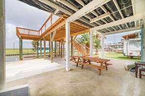Un espacio al aire libre cubierto con mesas de picnic y una escalera que conduce a un nivel superior.