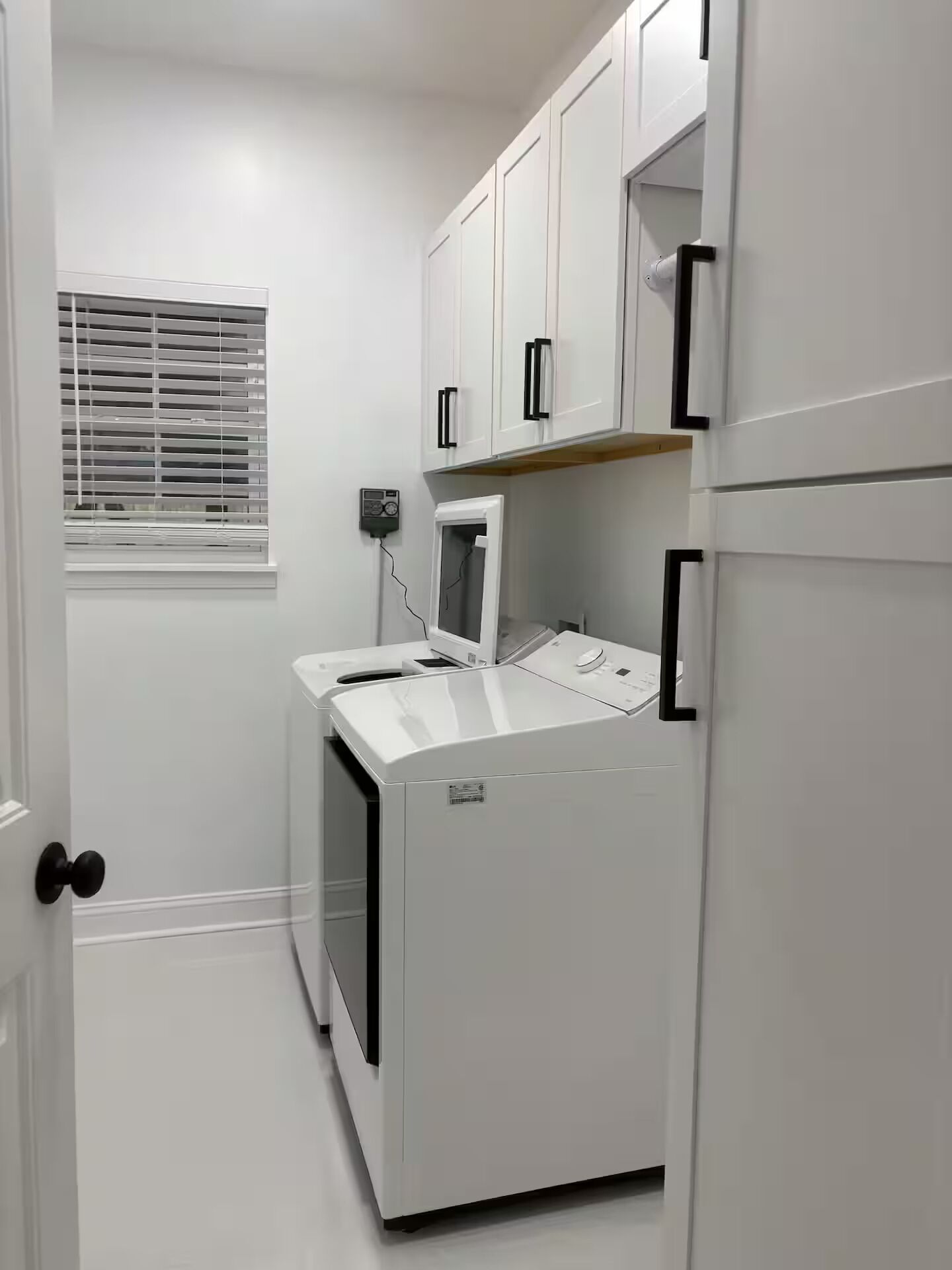 A compact kitchen with white cabinets, a microwave, and a built-in oven.
