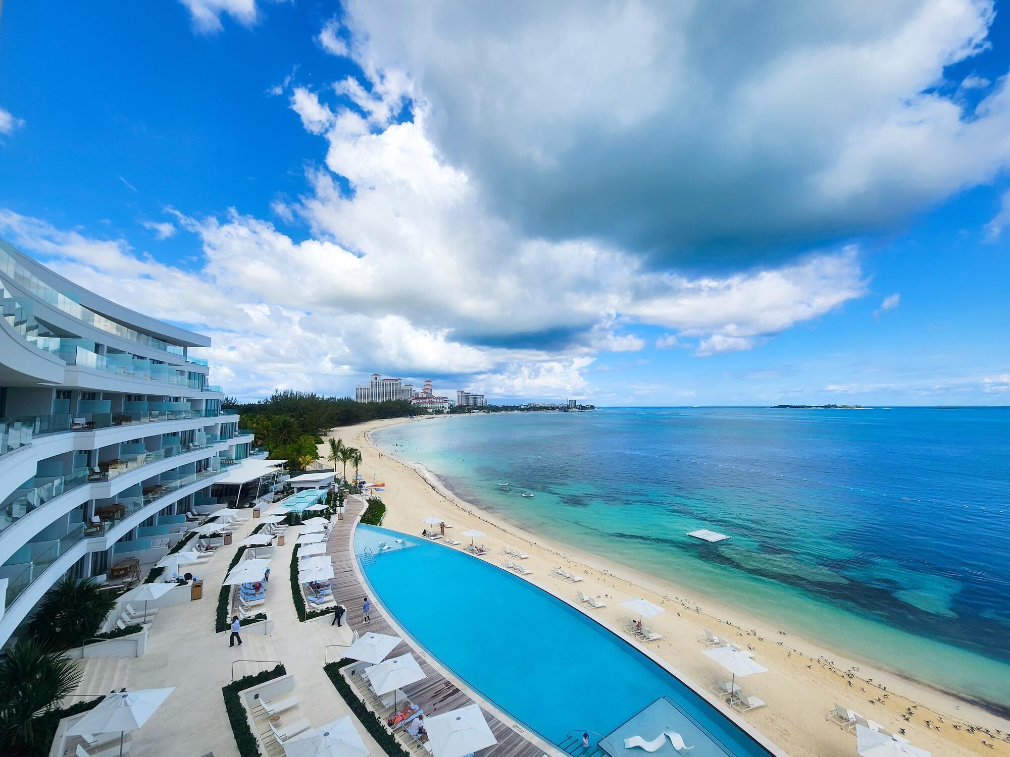 A resort with a pool, beach, and ocean view.