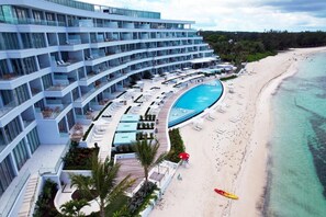 A modern hotel with multiple balconies, a pool, and a beach. - 2 bedrooms, 2 baths, luxury, most beautiful beach, Ocean view. 46 nights minimum (Nassau)