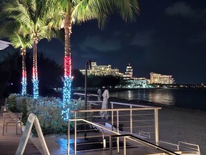 A waterfront hotel with a pool area, palm trees, and a view of the city skyline at night. - 2 bedrooms, 2 baths, luxury, most beautiful beach, Ocean view. 46 nights minimum (Nassau)