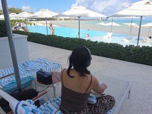 A poolside area with lounge chairs, umbrellas, and a view of the beach. - 2 bedrooms, 2 baths, luxury, most beautiful beach, Ocean view. 46 nights minimum (Nassau)