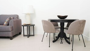 A modern living room with a grey sofa, a small round table with a bowl on top, and a lamp with a textured base. - 2 bedrooms, 2 baths, luxury, most beautiful beach, Ocean view. 46 nights minimum (Nassau)