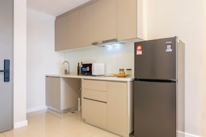 A compact kitchen with a built-in refrigerator, a microwave, and a sink. - Skyline Premier Suites Kuala Lumpur (Kuala Lumpur)