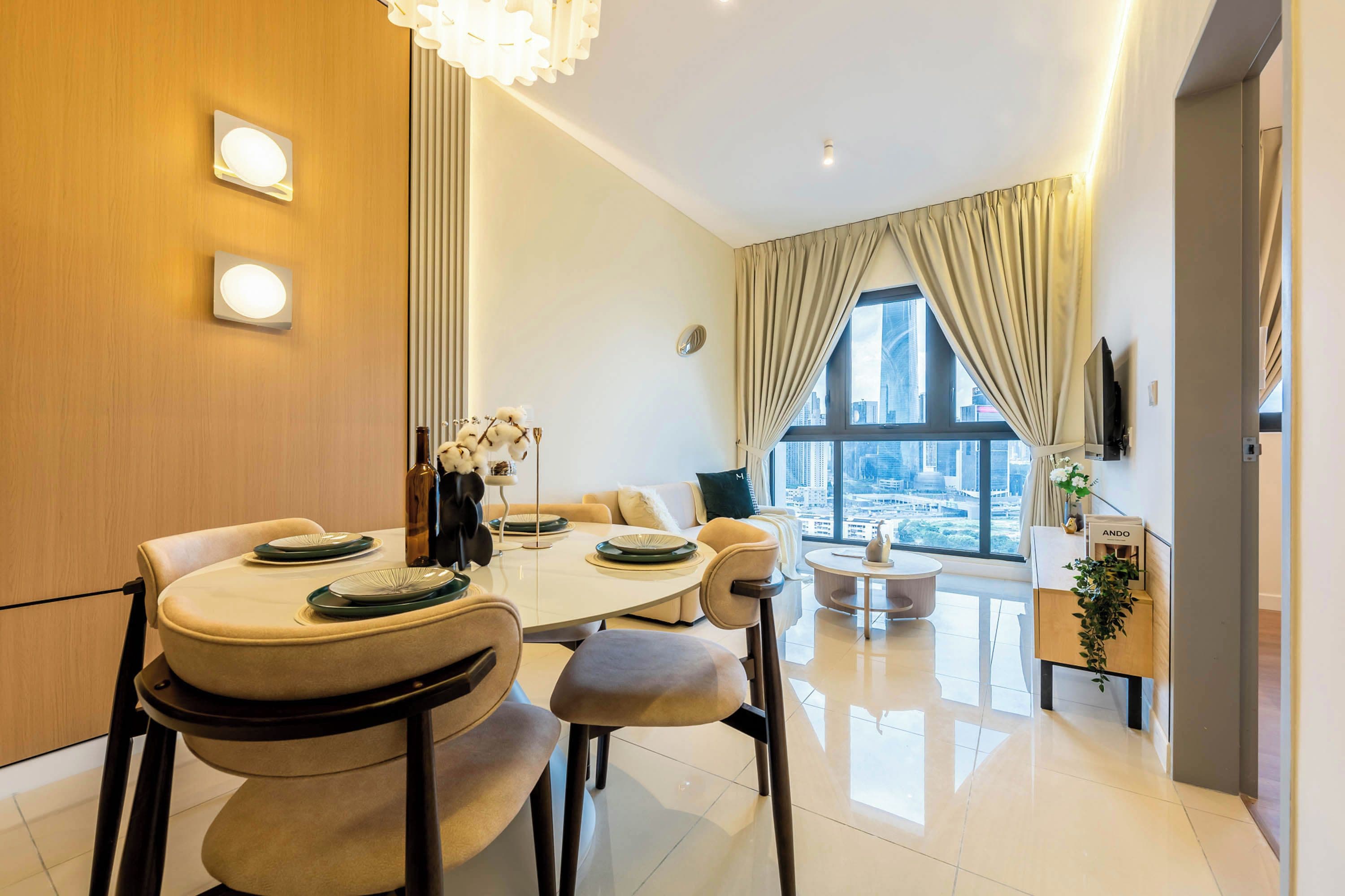 A modern dining area with a round table, chairs, and a view of the cityscape through large windows.