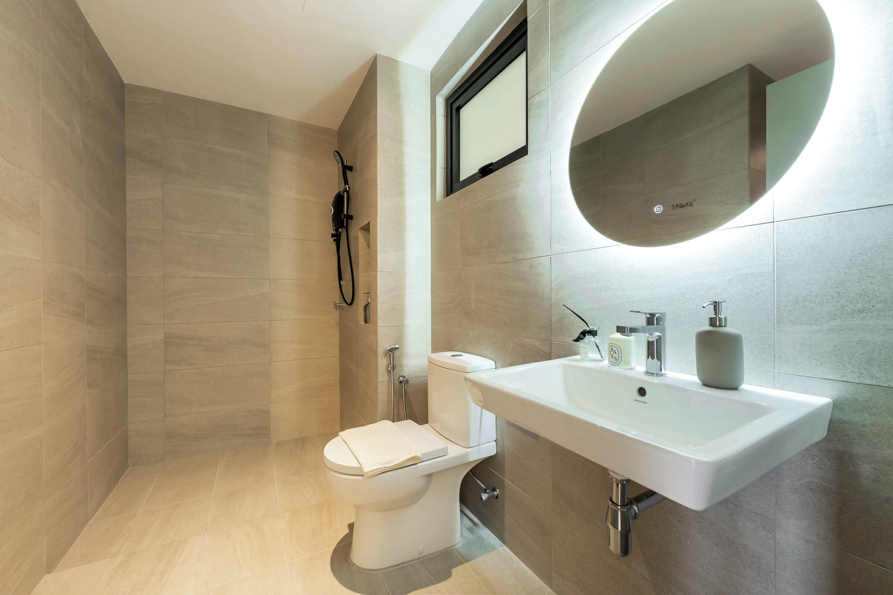 A modern bathroom with a toilet, shower, and sink.