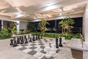 A chessboard set up outdoors with a cityscape view in the background. - Skyline Premier Suites Kuala Lumpur (Kuala Lumpur)