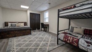 A bedroom with a bunk bed, a desk, and a chair. - Northwoods Lakefront Retreat! Swim, Fish, Relax (Rhinelander)