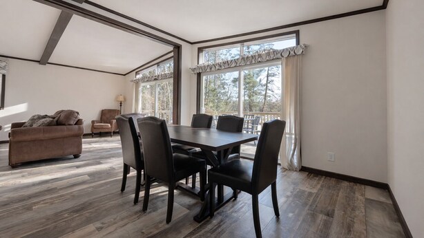 A spacious room with a dining table, chairs, a sofa, and large windows. - Northwoods Lakefront Retreat! Swim, Fish, Relax (Rhinelander)