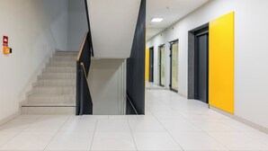A modern interior with a staircase, a hallway, and doors. - Modlińska Riverside Comfort Apartment (Warszawa)