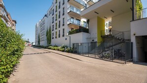 A modern apartment building with multiple balconies, a gated entrance, and a clear sky. - Modlińska Riverside Comfort Apartment (Warszawa)