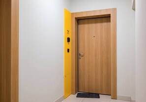 Une porte en bois avec une touche de jaune et un paillasson.