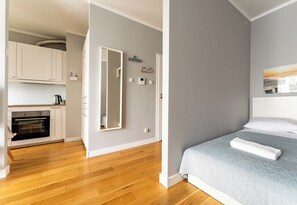Quarto moderno com cama, mesa de cabeceira e espelho fixado na parede.