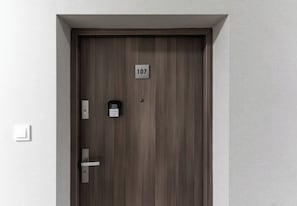 A door with a number plate, a keyhole, and a lock. - Podwisłocze Modern Apartment (Rzeszów)