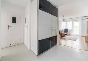 Quarto moderno com porta deslizante, um pequeno espaço de estar e uma janela ampla.