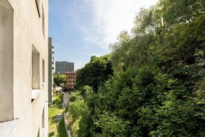 Un sendero atraviesa una zona verde exuberante con un edificio a un lado.