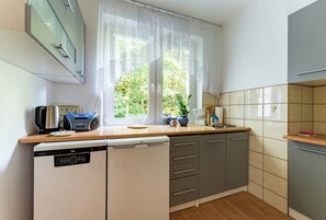 A compact kitchen with a dishwasher, a microwave, and a toaster. - Spadzista Comfort Apartment (Gdańsk)