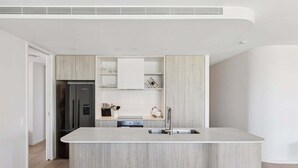 Eine moderne Küche mit Kochinsel, integrierten Geräten und minimalistischem Design.