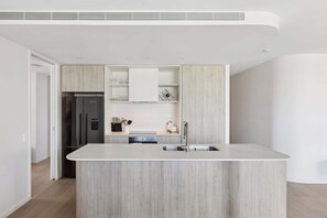 Eine moderne Küche mit Kochinsel, integrierten Geräten und minimalistischem Design.