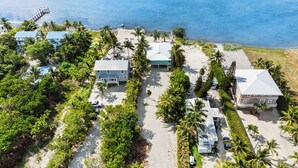 A coastal property with multiple buildings, a beach, and palm trees. - Oceanfront Beach House 3BR|3BA Newly renovated (Marathon)