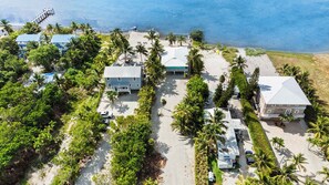A coastal property with multiple buildings, a beach, and palm trees. - Oceanfront Beach House 3BR|3BA Newly renovated (Marathon)