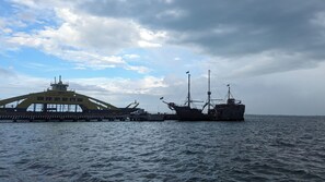 Um grande navio atracado no cais, com céu limpo e mar calmo.