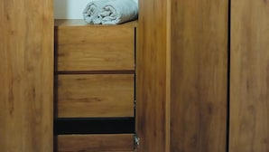 A wooden wardrobe with a folded towel on top.