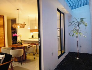 A modern dining area with a round table, chairs, and pendant lighting.