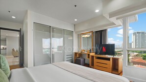 A modern hotel room with a bed, a desk, a mirror, and a TV. - Solea by Kozystay - Senayan (South Jakarta)