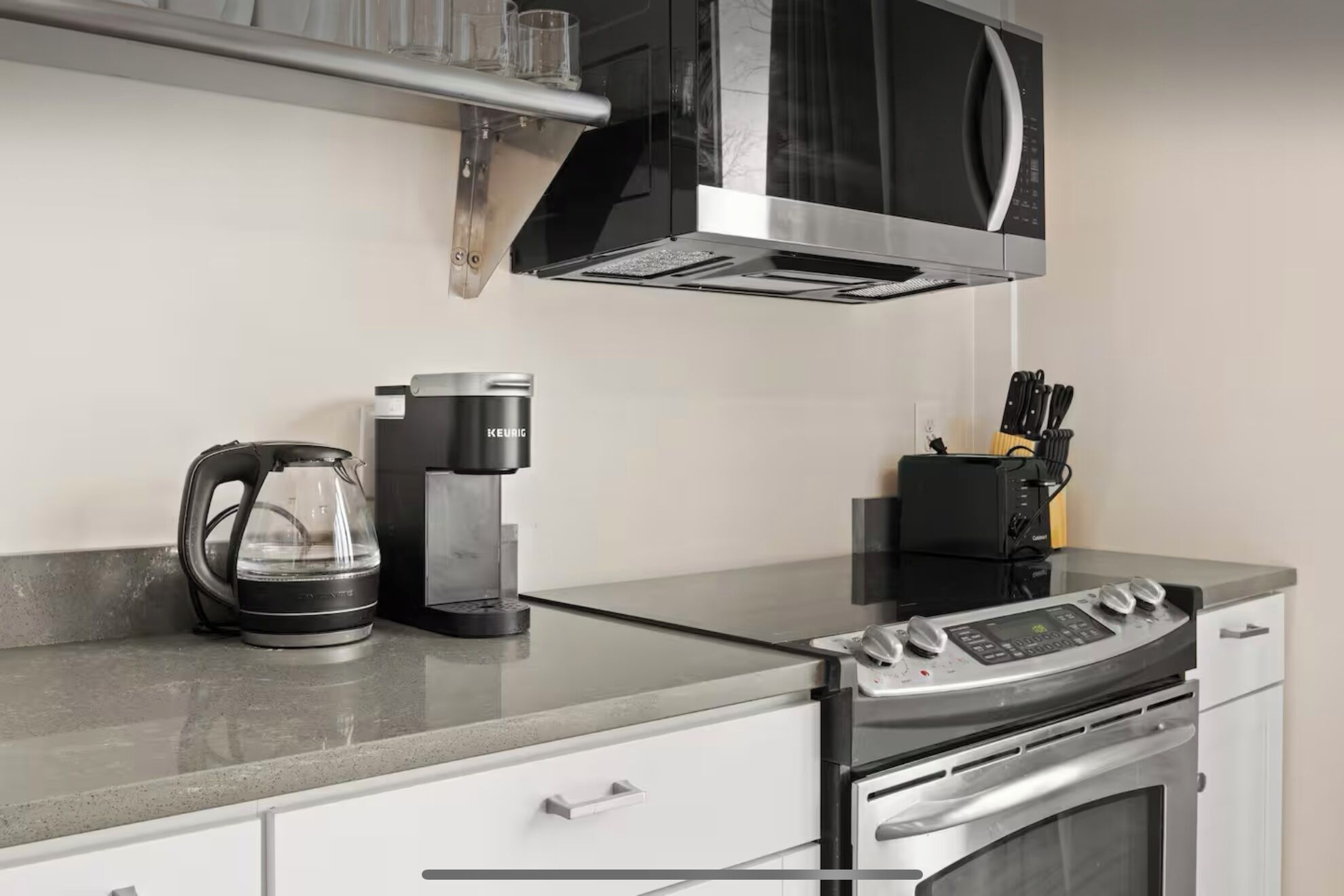 Una cocina moderna equipada con microondas, cafetera, tostadora y horno.