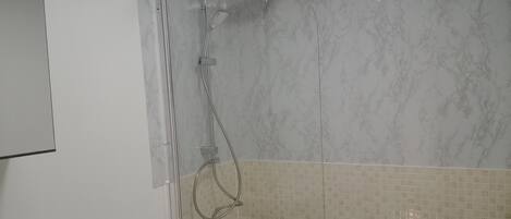Un baño con bañera, ducha y retrete.