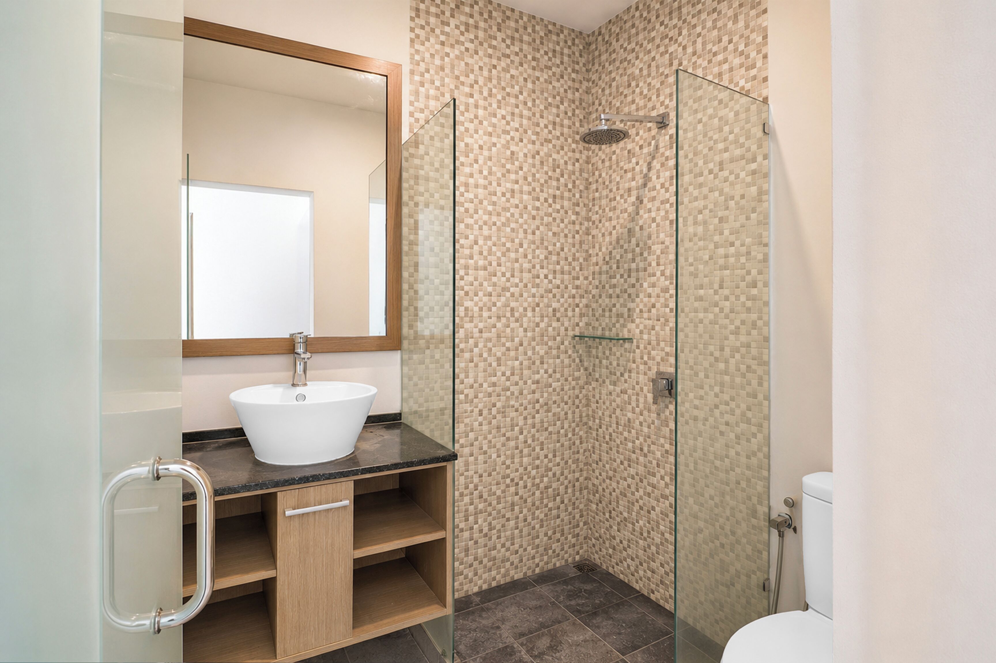 A bathroom with a white sink, a glass shower enclosure, and a toilet.