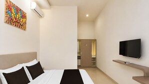 Una habitación de hotel con cama, televisión, un cuadro y armario.
