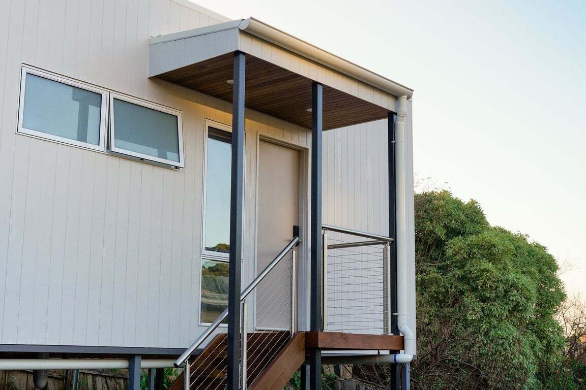 A modern building with a balcony, a staircase, and a window.