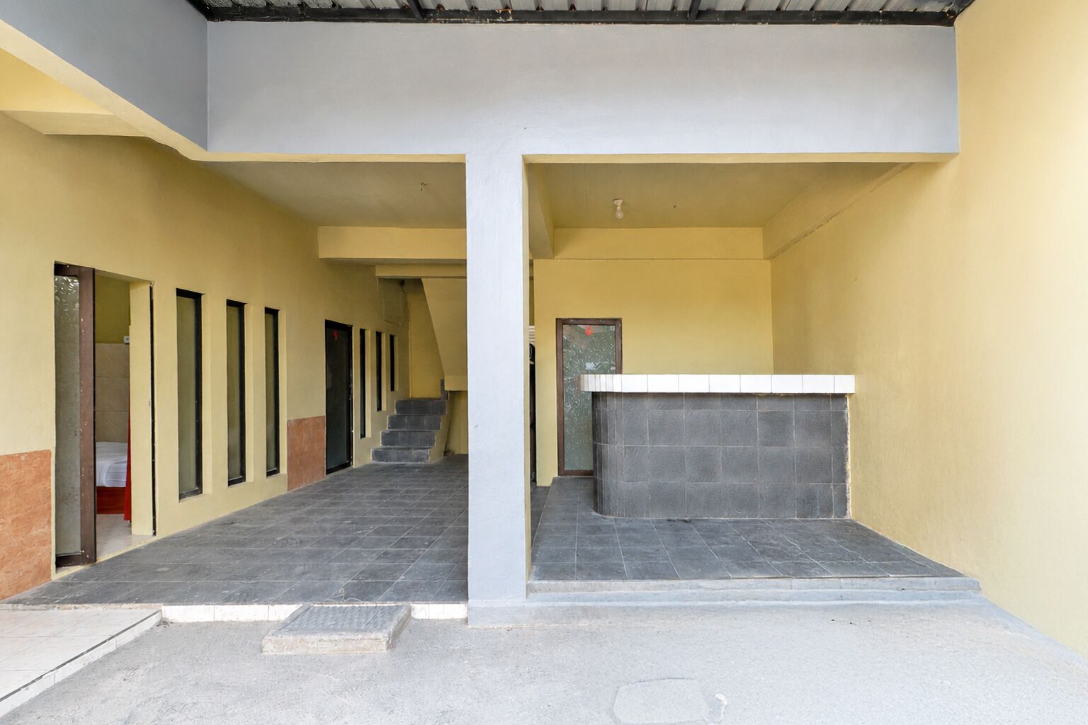 Un edificio con una escalera central, una recepción y una serie de ventanas a la izquierda.