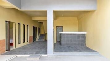 Un edificio con una escalera central, una recepción y una serie de ventanas a la izquierda.
