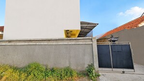 Un bâtiment doté d’un grand mur blanc, d’un mur gris et d’un toit recouvert de tuiles.