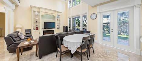 Un grand espace de vie comprenant une table à manger, des canapés et un téléviseur.