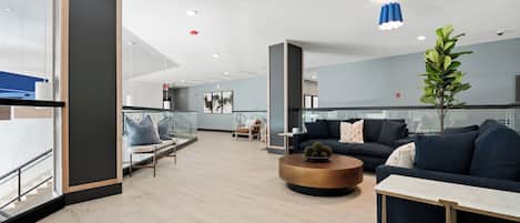 A modern interior with seating areas, a coffee table, and a plant.