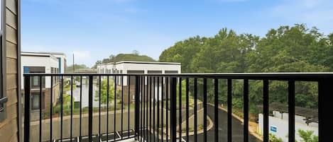 Ein Balkon mit Blick auf einen Parkplatz und Gebäude.
